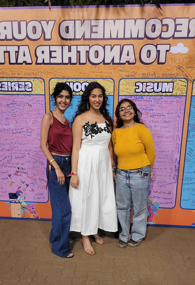 Diya with friends at a festival wall